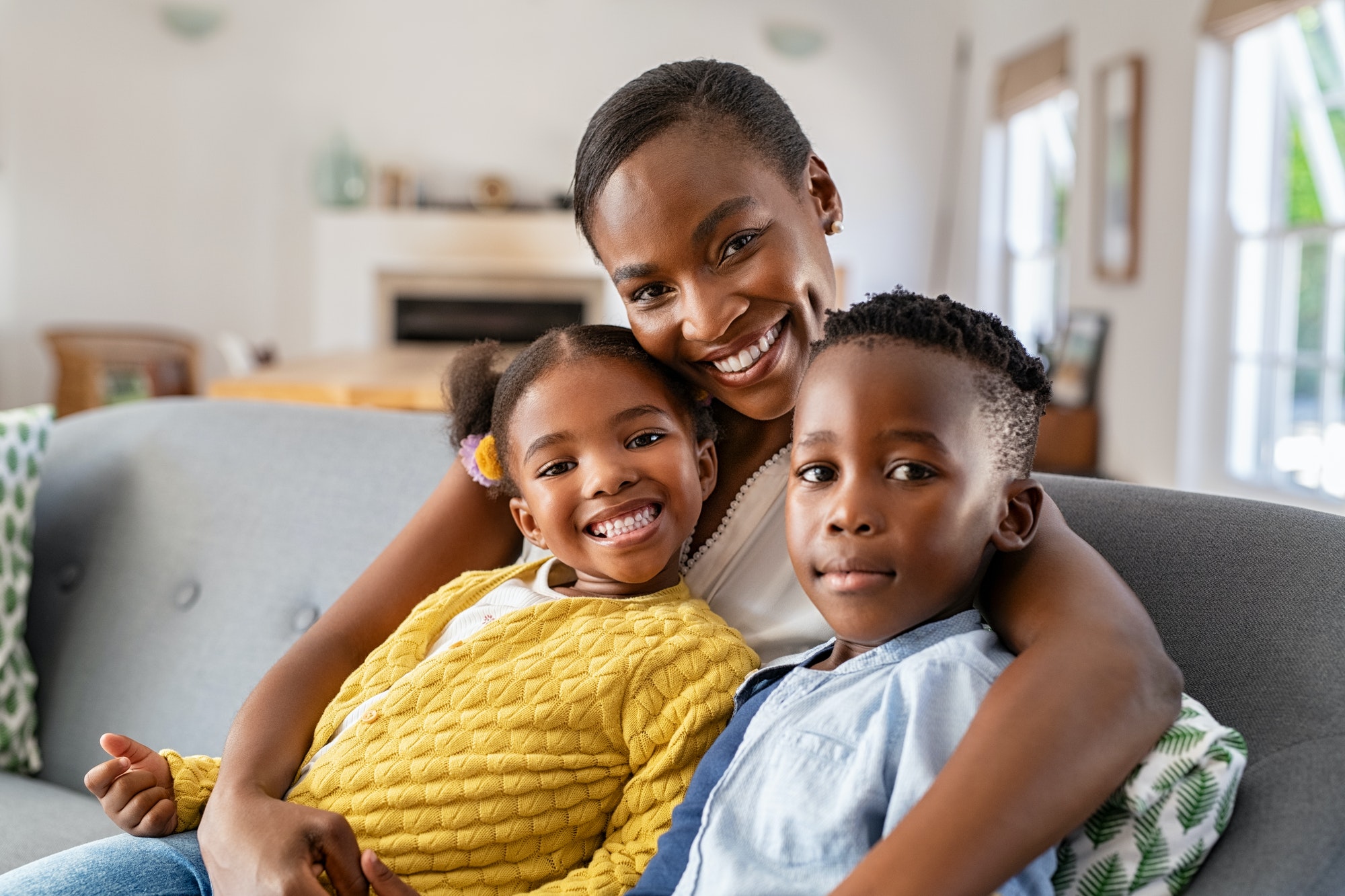 Happy african american mother with little son and smiling daughter